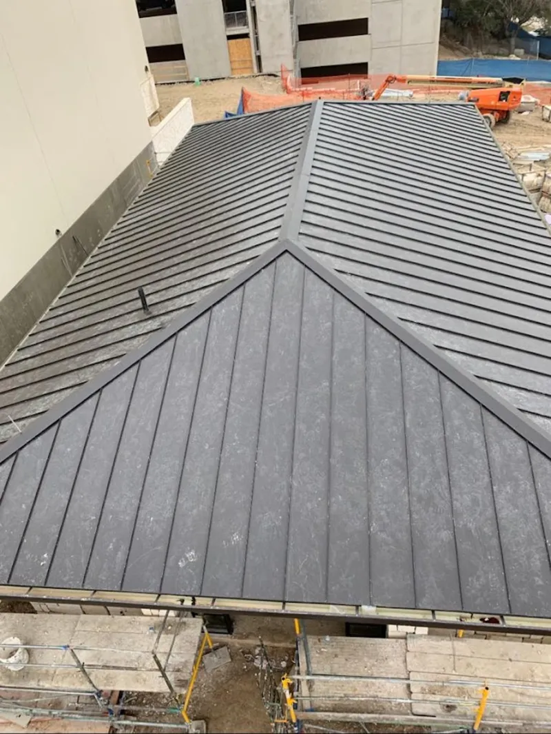 Commercial metal roof construction with crane equipment in Bethel
